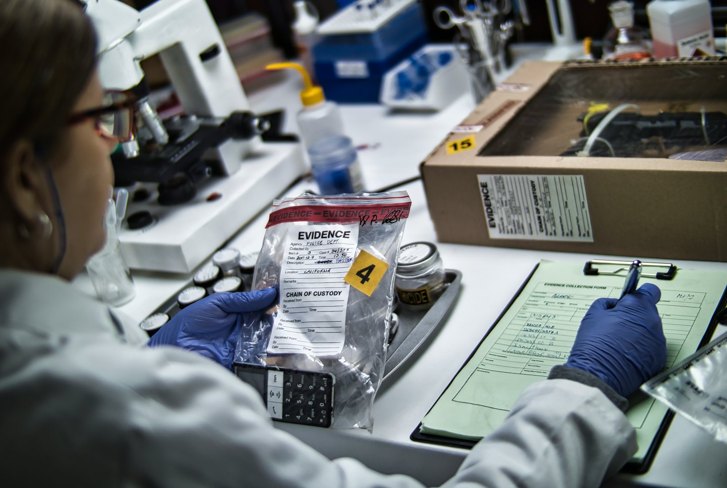Tecnico forense che documenta prove da un telefono cellulare in laboratorio.