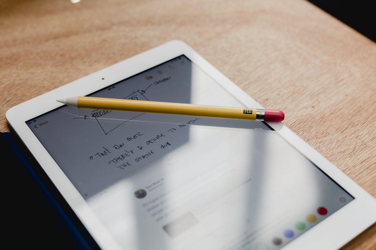 Tablet con appunti e stilo su un tavolo di legno.